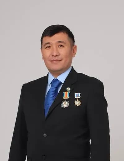 Қалдарбек Сраиловтың студиялық портреті: қою костюм, көкірегінде екі марапат
