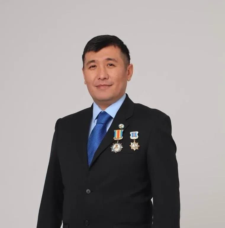 Қалдарбек Сраиловтың студиялық портреті: қою костюм, көкірегінде екі марапат